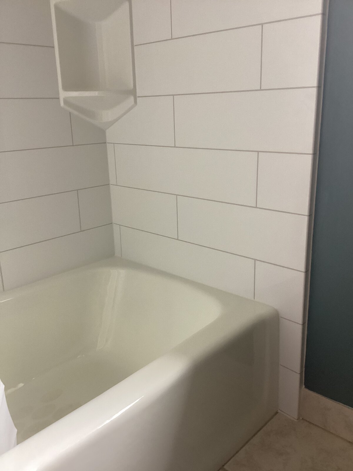 Finished replacement bathtub with marble-look surround and grab bars