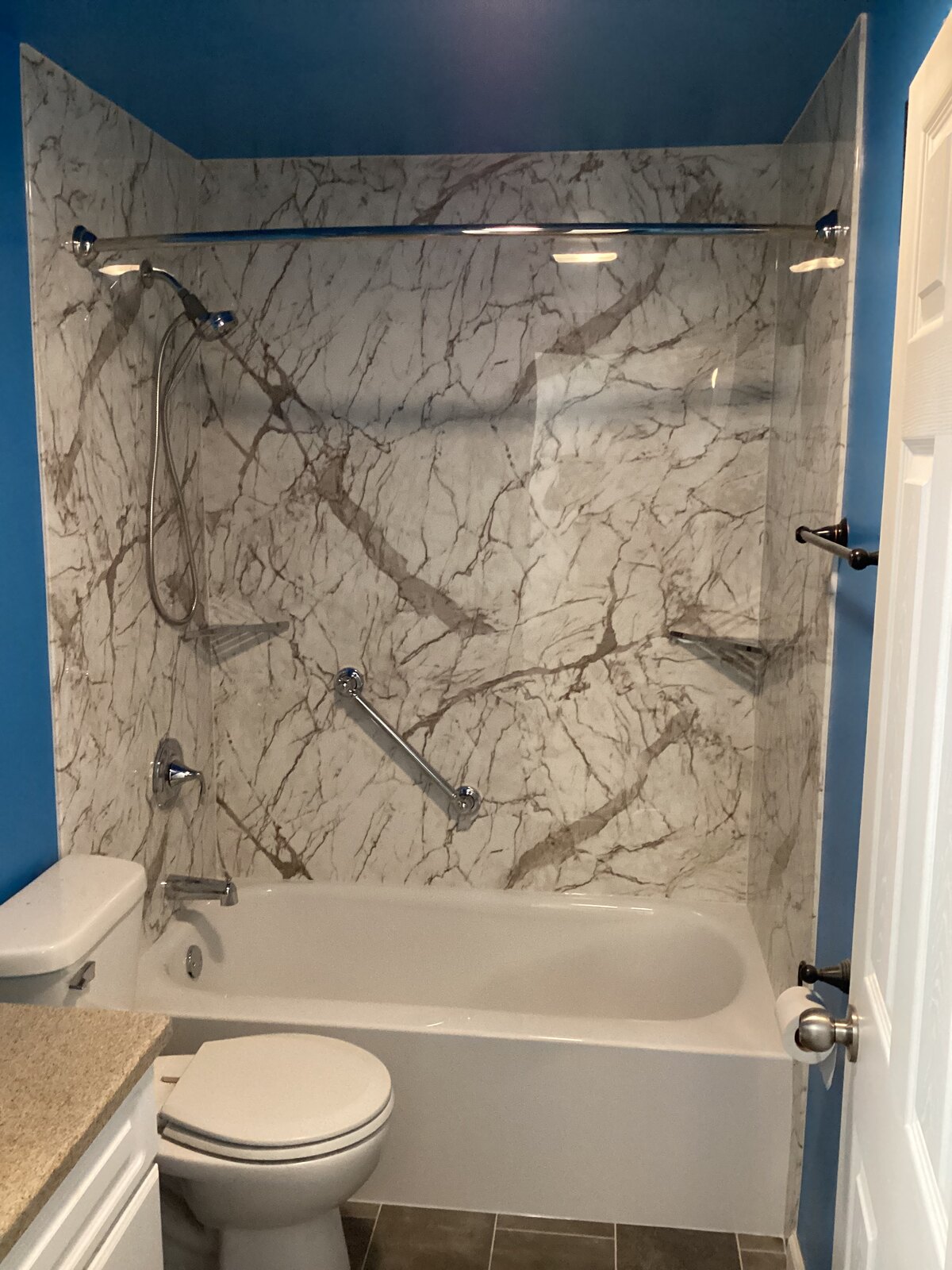 Finished replacement bathtub with white surround and corner shelves