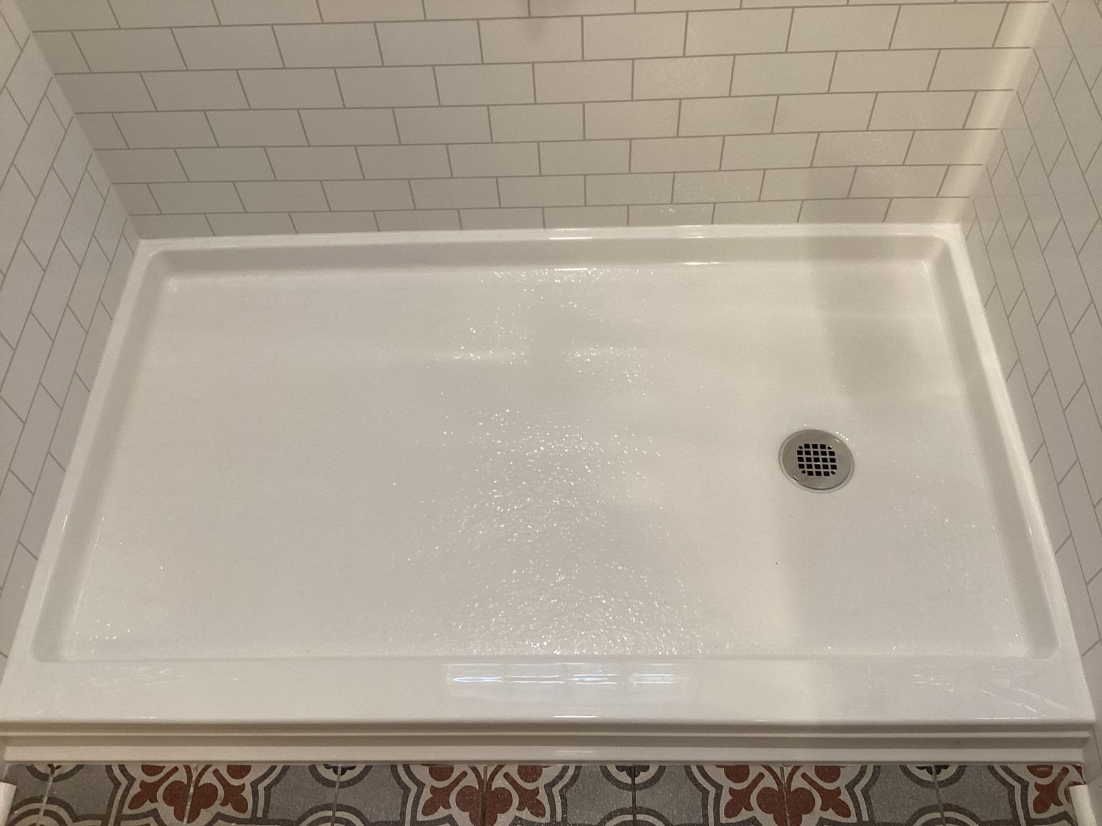 Finished white shower base with subway-look wall surround after the conversion