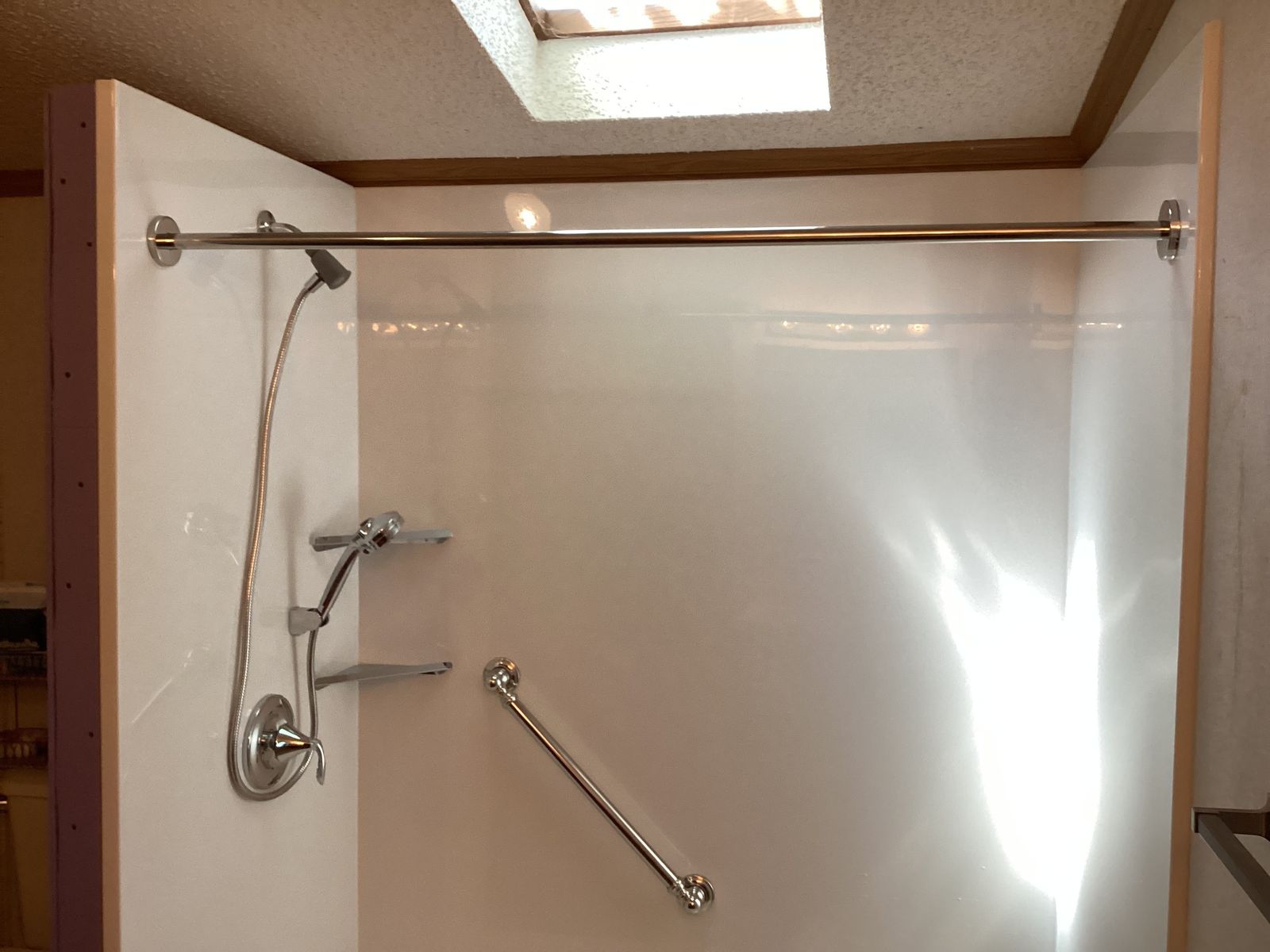 Completed shower conversion with skylight and chrome fixtures