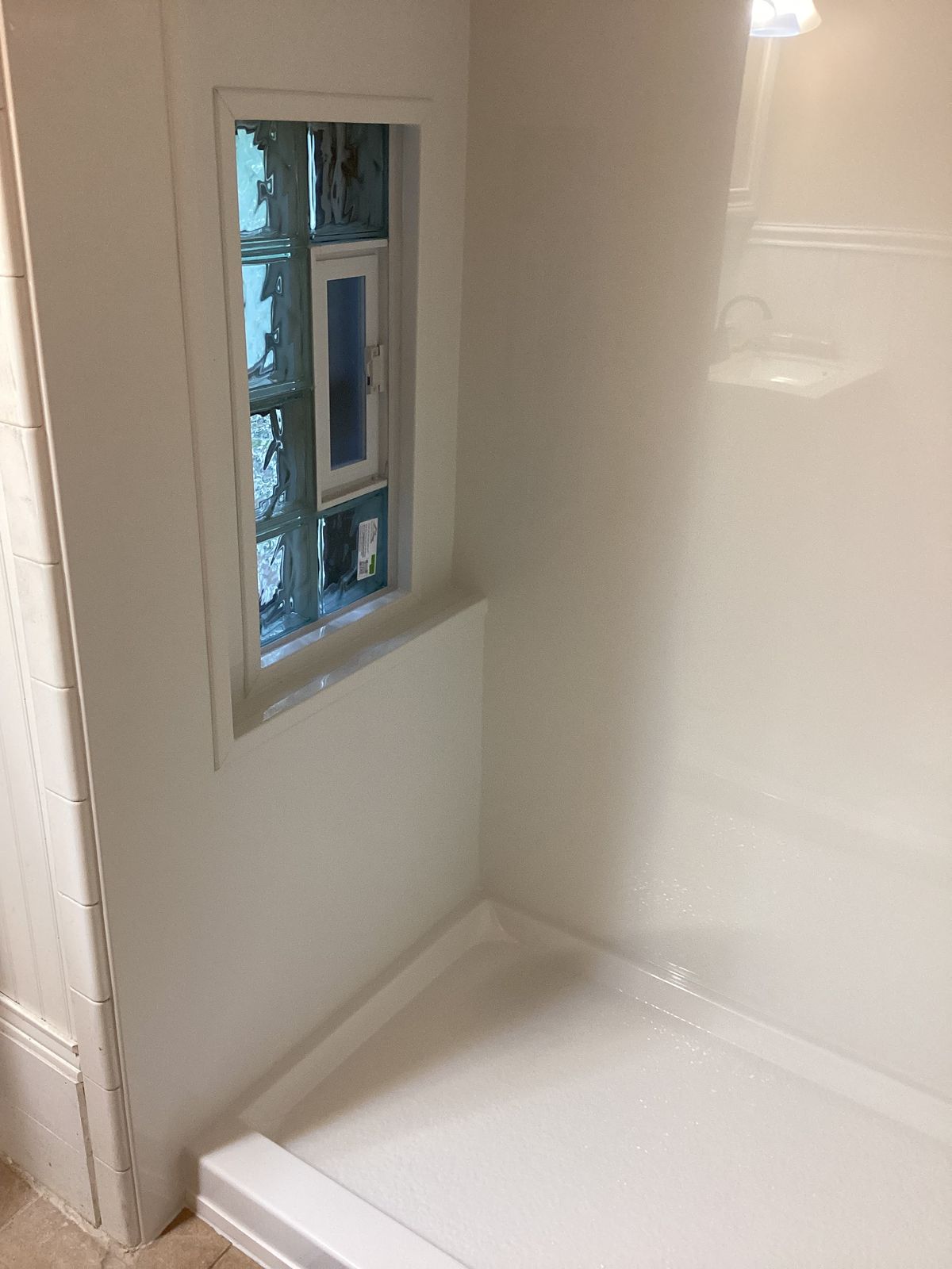 Finished shower with glass block window and smooth wall panels