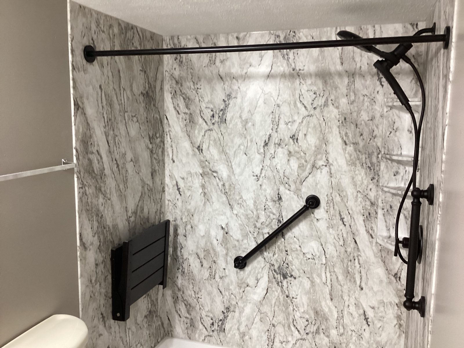 Handheld shower head and caddy in a marble-look shower