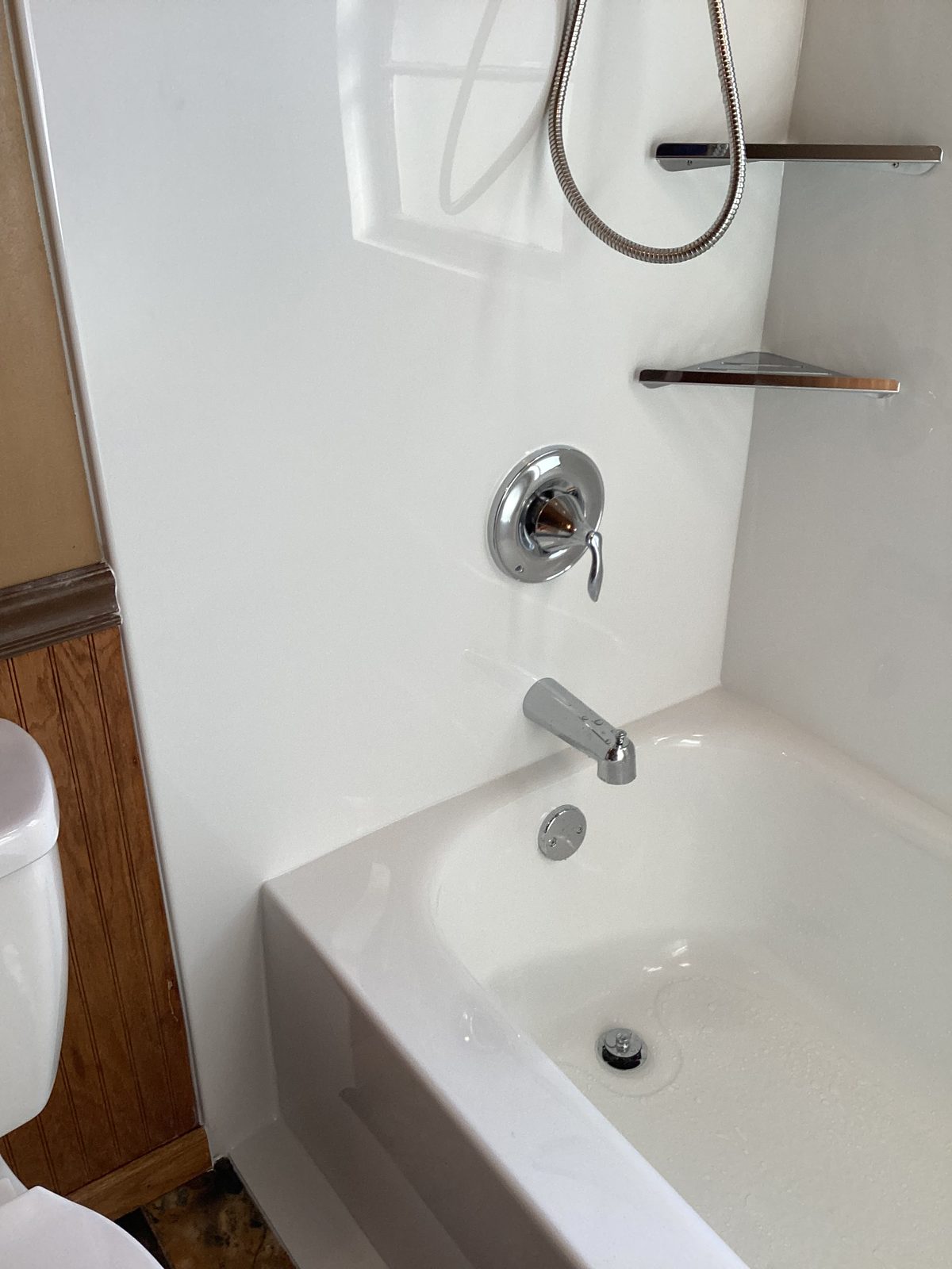 Tub faucet, valve and handheld shower on the new wall surround