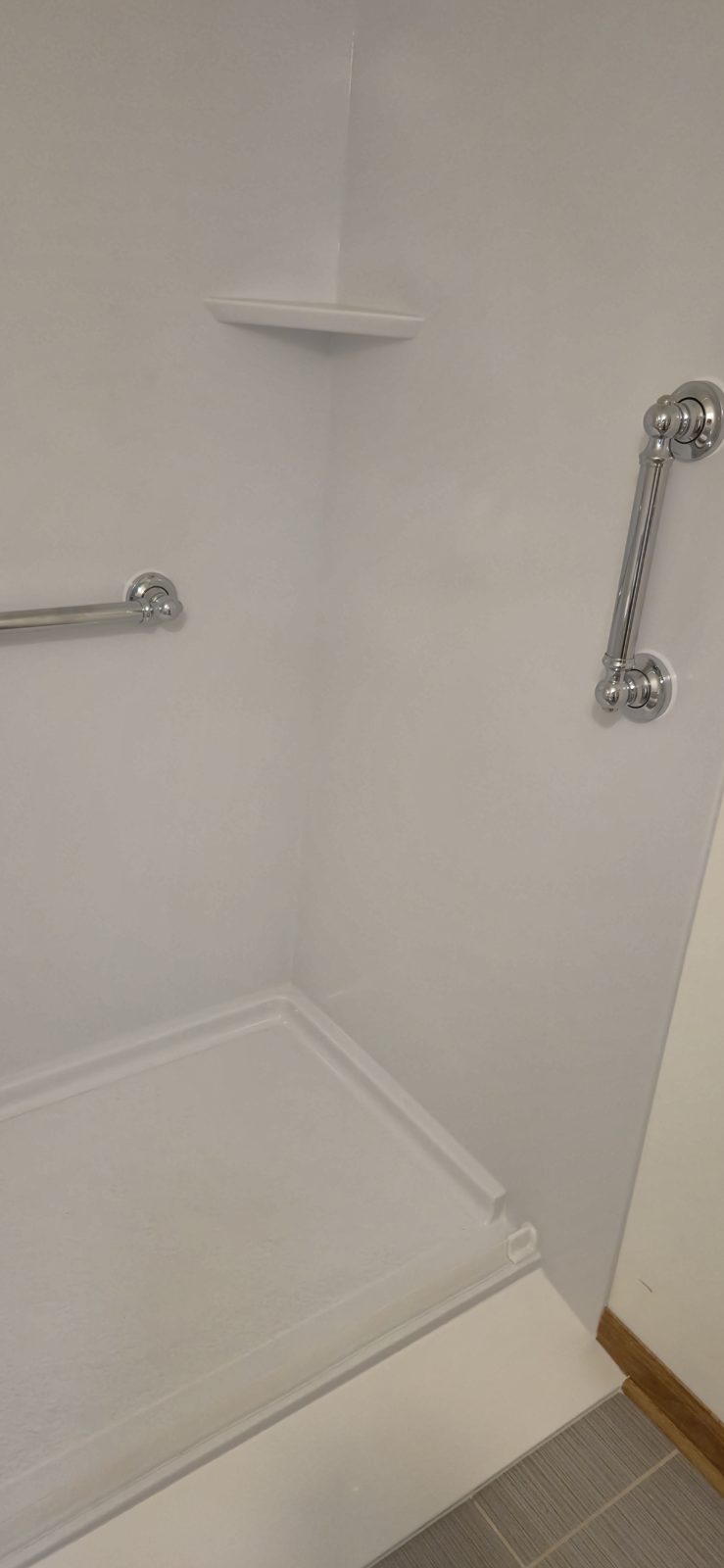Wheelchair-accessible ramped shower base with two grab bars