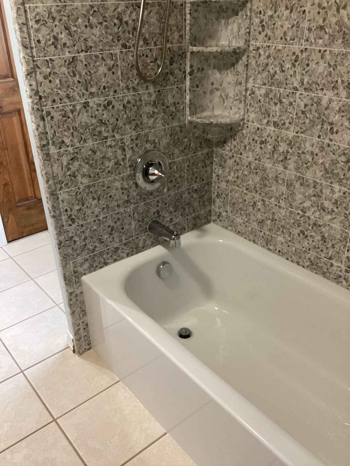 Stone-look tile pattern shower floor and tub with light grout lines