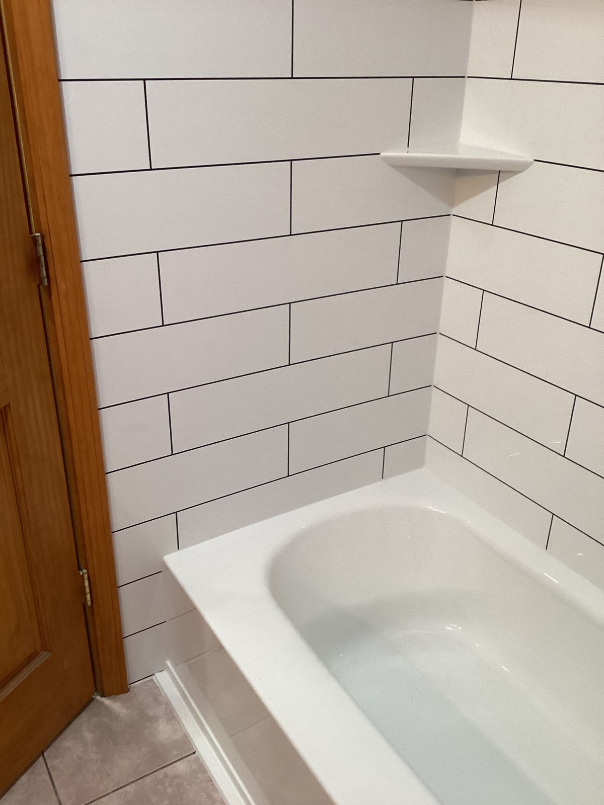 White subway tile-look tub surround with light grey grout lines